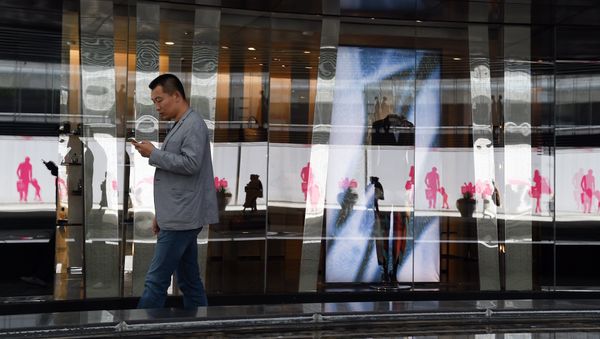 A man walks past stores in a shopping mall in Beijing on the second day of the National Day holidays on October 2, 2015 - Sputnik International