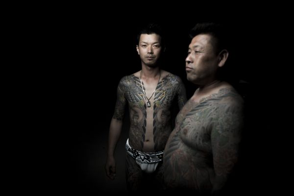 In this picture taken on May 20, 2017, men pose for photographs showing their Irezumi Japanese traditional tattoos related to the Yakuza's universe, during the Sanja Matsuri festival in Tokyo - Sputnik International