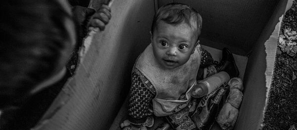 A baby sits in a cardboard box in the Idomeni camp on the Greek-Macedonian border A baby sits in a cardboard box in the Idomeni camp on the Greek-Macedonian border - Sputnik International