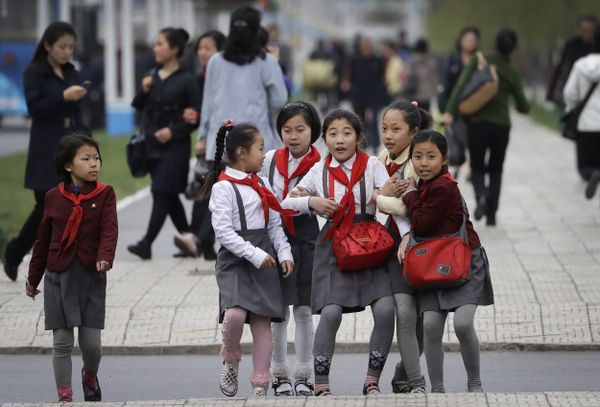 North Korean school girls react upon seeing their photograph being taken as they walk along Mirae Scientists Street in Pyongyang - Sputnik International