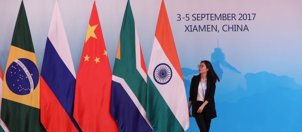 A staff worker walks past the national flags of Brazil, Russia, China, South Africa and India before a group photo during the BRICS Summit at the Xiamen International Conference and Exhibition Center in Xiamen, southeastern China's Fujian Province, China September 4, 2017 A staff worker walks past the national flags of Brazil, Russia, China, South Africa and India before a group photo during the BRICS Summit at the Xiamen International Conference and Exhibition Center in Xiamen, southeastern China's Fujian Province, China September 4, 2017 - Sputnik International