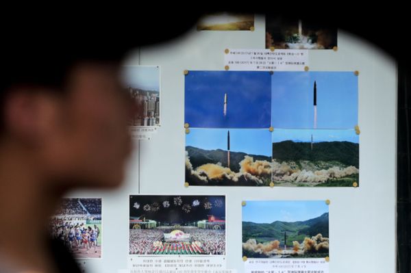 A man drives his car past a display board showing photos of ballistic missile launches in North Korea outside the North Korean Embassy in Beijing A man drives his car past a display board showing photos of ballistic missile launches in North Korea outside the North Korean Embassy in Beijing - Sputnik International