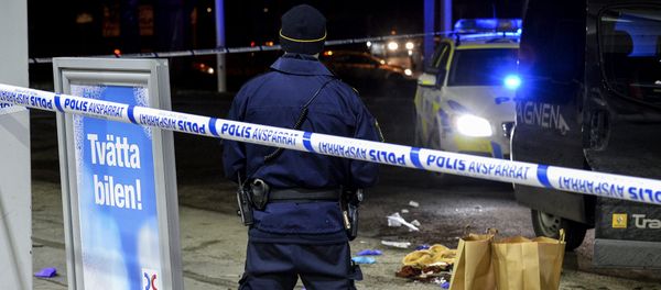 A police officer stands inside a roped off an area on a gas station in Fittja, Sweden, where a man was found severely injured in a minivan after being shot at when taking part in a pro-Kurdish demonstration Saturday, Feb. 13, 2016 A police officer stands inside a roped off an area on a gas station in Fittja, Sweden, where a man was found severely injured in a minivan after being shot at when taking part in a pro-Kurdish demonstration Saturday, Feb. 13, 2016 - Sputnik International