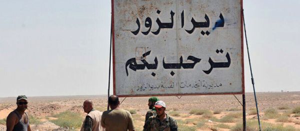 This photo released on Sunday, Sept 3, 2017 by the Syrian official news agency SANA, shows Syrian troops and pro-government gunmen standing next to a placard in Arabic which reads, Deir el-Zour welcomes you, in the eastern city of Deir el-Zour, Syria - Sputnik International