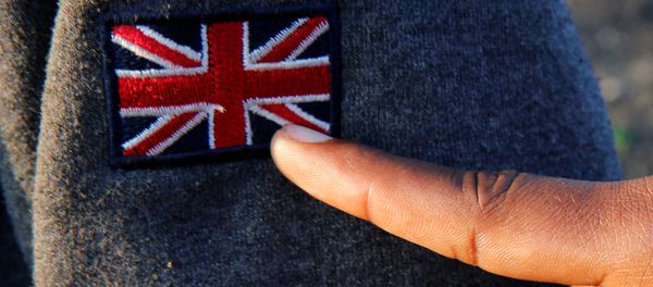 An Ethiopian migrant named Ermias (16 years old) points at an Union Jack patch as he waits on line during a food distribution near the former jungle in Calais, France, August 23, 2017 An Ethiopian migrant named Ermias (16 years old) points at an Union Jack patch as he waits on line during a food distribution near the former jungle in Calais, France, August 23, 2017 - Sputnik International