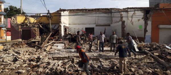 Residents stand on debris of a partially collapsed building felled by a massive earthquake in Juchitan, Oaxaca state, Mexico, Friday, Sept. 8, 2017. - Sputnik International
