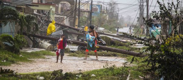 Residents walk near downed power lines felled by Hurricane Irma, in Caibarien, Cuba, Saturday, Sept. 9, 2017 - Sputnik International
