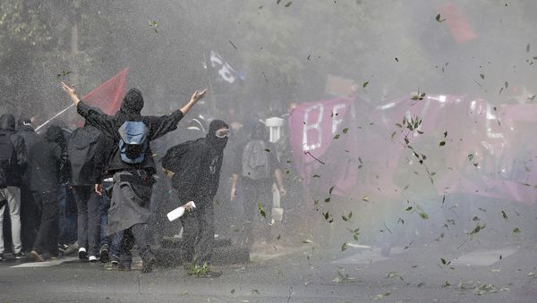 Demonstrators take cover after clashing with police during a protest march against President Emmanuel Macron's new pro-business labor policies in Paris, Tuesday, Sept. 12, 2017 - Sputnik International