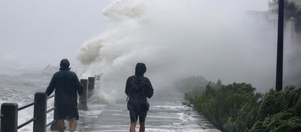Pedestrians walk into huge waves crashing over The Battery as Tropical Storm Irma hits Charleston, S.C - Sputnik International