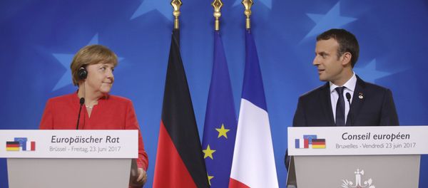 German Chancellor Angela Merkel, left, and French President Emmanuel Macron prepare to address the media at an EU summit in Brussels on Friday, June 23, 2017. - Sputnik International