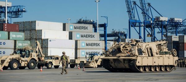 Soldiers walk near U.S. military equipment which arrived as part of NATO mission at port in Gdansk, Poland - Sputnik International