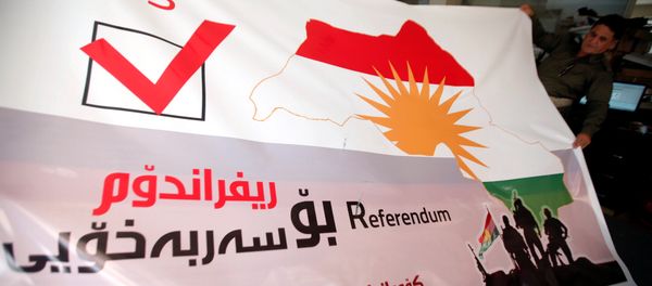A man holds a printed banner of Kurdistan region referendum in Erbil, Iraq August 26, 2017. Picture taken August 26, 2017 - Sputnik International