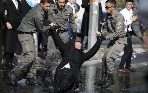 Members of the Israeli security forces drag an ultra-Orthodox Jewish demonstrator in an ultra-Orthodox neighbourhood of Jerusalem on September 17, 2017 during a protest against a court ruling that could require them to serve in the army like their secular counterparts Members of the Israeli security forces drag an ultra-Orthodox Jewish demonstrator in an ultra-Orthodox neighbourhood of Jerusalem on September 17, 2017 during a protest against a court ruling that could require them to serve in the army like their secular counterparts - Sputnik International