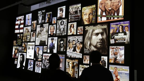 People looking at covers of the Rolling Stone magazines at the Rolling Stone 50 Years exhibit at the Rock and Roll Hall of Fame, in Cleveland - Sputnik International