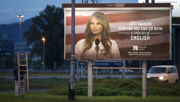 A worker carrying a ladder walks past a billboard depicting the first lady Melania Trump and advertising a language school displayed in Zagreb, Croatia, Friday, Sept. 15, 2017. - Sputnik International