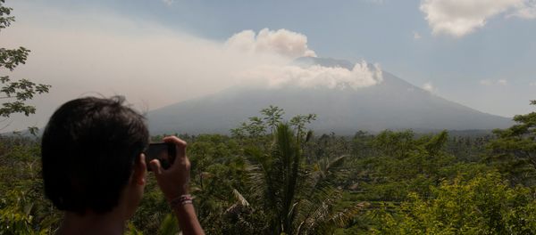 A local resident takes a picture of Mount Agung, an active volcano that authorities say is showing increased activity, from a monitoring station in Rendang Village, Karangasem on the resort island of Bali, Indonesia September 19, 2017 - Sputnik International