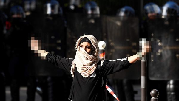 A demonstrator sticks up her middle fingers next to riot police during a rally in Paris on September 21, 2017, against the French government's proposed labour law reforms A demonstrator sticks up her middle fingers next to riot police during a rally in Paris on September 21, 2017, against the French government's proposed labour law reforms - Sputnik International