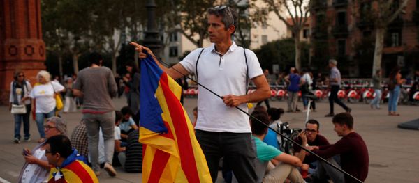 A man places an Estelada (Catalan separatist flag) on a stick during a protest outside the High Court of Justice of Catalonia in Barcelona, Spain, September 21, 2017. A man places an Estelada (Catalan separatist flag) on a stick during a protest outside the High Court of Justice of Catalonia in Barcelona, Spain, September 21, 2017. - Sputnik International