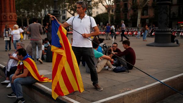 A man places an Estelada (Catalan separatist flag) on a stick during a protest outside the High Court of Justice of Catalonia in Barcelona, Spain, September 21, 2017. A man places an Estelada (Catalan separatist flag) on a stick during a protest outside the High Court of Justice of Catalonia in Barcelona, Spain, September 21, 2017. - Sputnik International