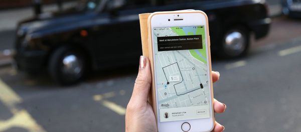 A woman poses holding a smartphone showing the App for ride-sharing cab service Uber in London on September 22, 2017 A woman poses holding a smartphone showing the App for ride-sharing cab service Uber in London on September 22, 2017 - Sputnik International