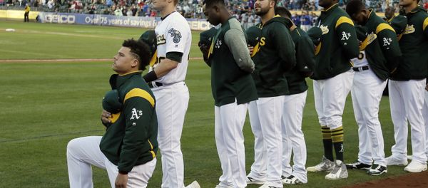 Oakland Athletics catcher Bruce Maxwell kneels during the national anthem before the start of a baseball game against the Texas Rangers Saturday, Sept. 23, 2017, in Oakland, Calif. Bruce Maxwell of the Oakland Athletics has become the first major league baseball player to kneel during the national anthem. - Sputnik International