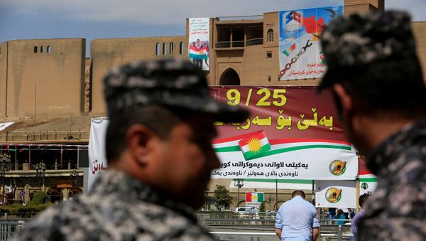 Kurdish policemen look on towards banners supporting the referendum for independence of Kurdistan in Erbil, Iraq September 24, 2017 - Sputnik International