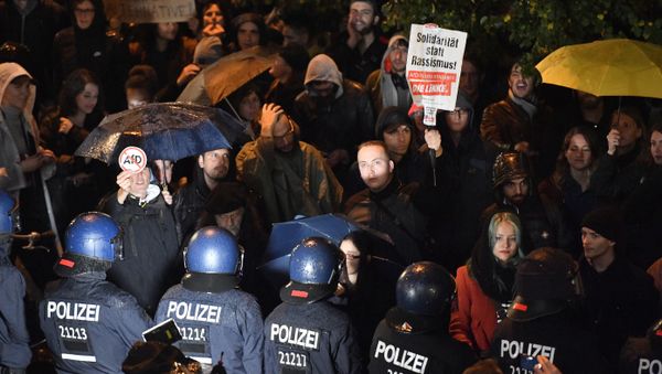 A man holds a banner reading Solidarity instead of Racism as police blocks demonstrators protesting against the nationalist 'Alternative for Germany', AfD, party in Berlin, Germany, Sunday, Sept. 24, 2017, after the polling stations for the German parliament elections had been closed - Sputnik International