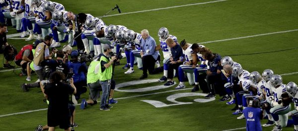 The Dallas Cowboys, led by owner Jerry Jones, center, take a knee prior to the national anthem prior to an NFL football game against the Arizona Cardinals, Monday, Sept. 25, 2017, in Glendale, Ariz. - Sputnik International