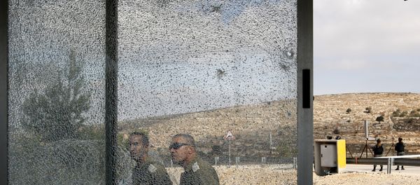 Members of the Israeli security forces walk past the shattered glass of the security post at the entrance to the West Bank settlement of Har Adar after a Palestinian opened fire on security personnel in a fatal attack before being shot dead Members of the Israeli security forces walk past the shattered glass of the security post at the entrance to the West Bank settlement of Har Adar after a Palestinian opened fire on security personnel in a fatal attack before being shot dead - Sputnik International