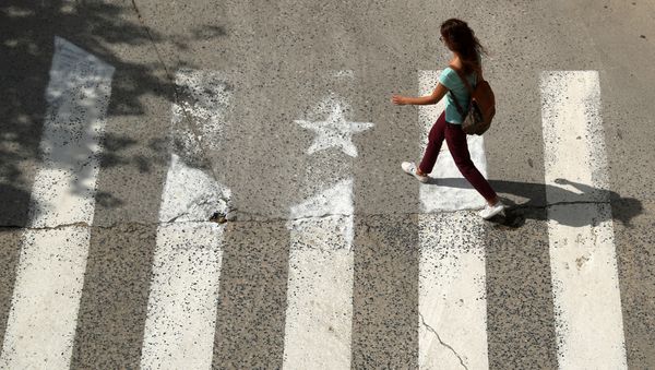 A woman walks past a crosswalk, painted in the form of an Estelada (Catalan pro-independence flag) in Arenys de Munt, north of Barcelona, Spain, September 26, 2017 A woman walks past a crosswalk, painted in the form of an Estelada (Catalan pro-independence flag) in Arenys de Munt, north of Barcelona, Spain, September 26, 2017 - Sputnik International