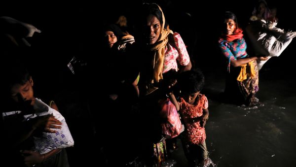 Women and children wade through the water as hundreds of Rohingya refugees arrive under the cover of darkness by wooden boats from Myanmar to the shore of Shah Porir Dwip, in Teknaf, near Cox's Bazar in Bangladesh, September 27, 2017 Women and children wade through the water as hundreds of Rohingya refugees arrive under the cover of darkness by wooden boats from Myanmar to the shore of Shah Porir Dwip, in Teknaf, near Cox's Bazar in Bangladesh, September 27, 2017 - Sputnik International