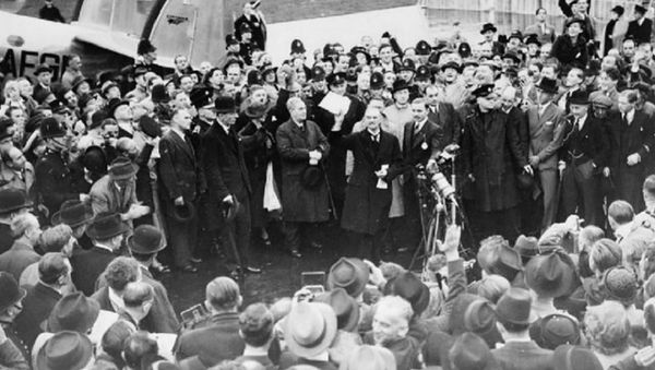 Neville Chamberlain holding the paper containing the resolution to commit to peaceful methods signed by both Hitler and himself on his return from Munich. He is showing the piece of paper to a crowd at Heston Aerodrome on 30 September 1938 - Sputnik International