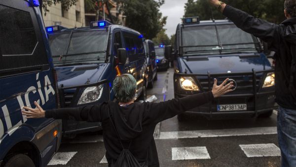 People try to stop Spanish police vans outside the Ramon Llull polling station in Barcelona October 1, 2017 during a referendum on independence for Catalonia banned by Madrid People try to stop Spanish police vans outside the Ramon Llull polling station in Barcelona October 1, 2017 during a referendum on independence for Catalonia banned by Madrid - Sputnik International