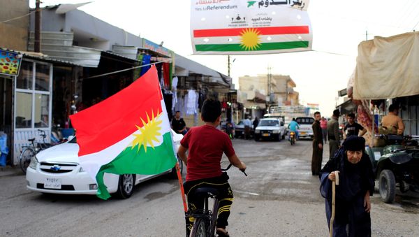 A boy rides a bicycle with the flag of Kurdistan in Tuz Khurmato, Iraq September 24, 2017 - Sputnik International