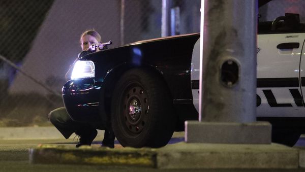 A police officer takes cover behind a police vehicle during a shooting near the Mandalay Bay resort and casino on the Las Vegas Strip, Sunday, Oct. 1, 2017, in Las Vegas A police officer takes cover behind a police vehicle during a shooting near the Mandalay Bay resort and casino on the Las Vegas Strip, Sunday, Oct. 1, 2017, in Las Vegas - Sputnik International