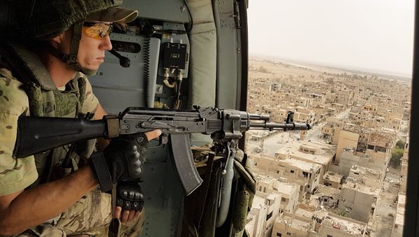 In this Friday, Sept. 15, 2017 file photo, a Russian soldier guards as a military helicopter flies over Palmyra, Syria - Sputnik International