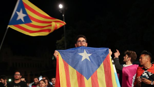 A man holds an Estelada (Catalan separatist flag) as people gather at Plaza Catalunya after voting ended for the banned independence referendum, in Barcelona, Spain A man holds an Estelada (Catalan separatist flag) as people gather at Plaza Catalunya after voting ended for the banned independence referendum, in Barcelona, Spain - Sputnik International