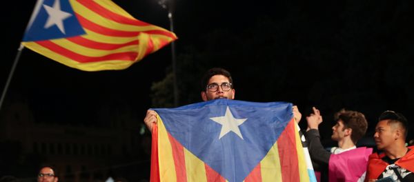 A man holds an Estelada (Catalan separatist flag) as people gather at Plaza Catalunya after voting ended for the banned independence referendum, in Barcelona, Spain A man holds an Estelada (Catalan separatist flag) as people gather at Plaza Catalunya after voting ended for the banned independence referendum, in Barcelona, Spain - Sputnik International
