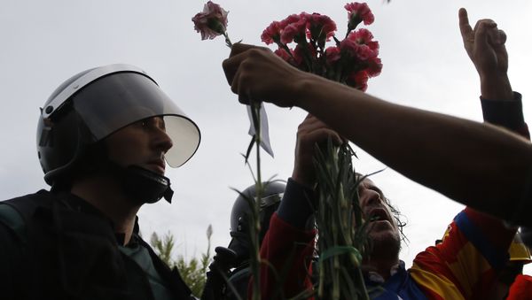 People try to offer flowers to a civil guard at the entrance of a sports center, assigned to be a referendum polling station by the Catalan government in Sant Julia de Ramis, near Girona, Spain, Sunday, Oct. 1, 2017. Scuffles have erupted as voters protested while dozens of anti-rioting police broke into a polling station where the regional leader was expected to show up for voting on Sunday. - Sputnik International