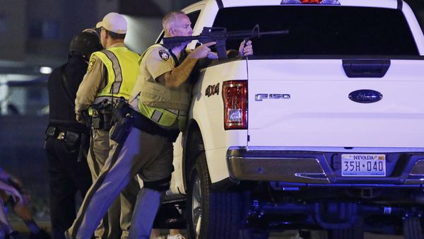 A police officer takes cover behind a truck at the scene of a shooting near the Mandalay Bay resort and casino on the Las Vegas Strip, Sunday, Oct. 1, 2017, in Las Vegas A police officer takes cover behind a truck at the scene of a shooting near the Mandalay Bay resort and casino on the Las Vegas Strip, Sunday, Oct. 1, 2017, in Las Vegas - Sputnik International