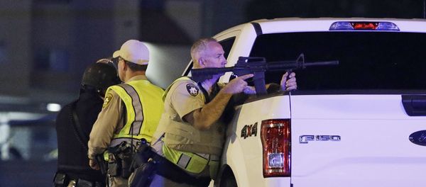 A police officer takes cover behind a truck at the scene of a shooting near the Mandalay Bay resort and casino on the Las Vegas Strip, Sunday, Oct. 1, 2017, in Las Vegas A police officer takes cover behind a truck at the scene of a shooting near the Mandalay Bay resort and casino on the Las Vegas Strip, Sunday, Oct. 1, 2017, in Las Vegas - Sputnik International