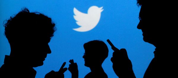 People holding mobile phones are silhouetted against a backdrop projected with the Twitter logo. (File) People holding mobile phones are silhouetted against a backdrop projected with the Twitter logo. (File) - Sputnik International