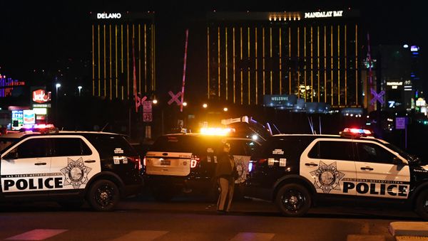 Police form a perimeter around the road leading to the Mandalay Hotel (background) after a gunman killed at least 50 people and wounded more than 200 others when he opened fire on a country music concert in Las Vegas, Nevada - Sputnik International