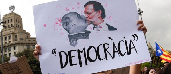 A woman holds up a banner reading Democracy depicting former Spanish dictator Francisco Franco kissing Spanish Prime Miniser Mariano Rajoy during a protest one day after the banned independence referendum in Barcelona, Spain, October 2, 2017. - Sputnik International