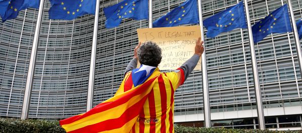 Catalan Raimon Castellvi wears a flag with an Estelada (Catalan separatist flag) as he protests outside the European Commission in Brussels after Sunday's independence referendum in Catalonia, Belgium, October 2, 2017. Catalan Raimon Castellvi wears a flag with an Estelada (Catalan separatist flag) as he protests outside the European Commission in Brussels after Sunday's independence referendum in Catalonia, Belgium, October 2, 2017. - Sputnik International