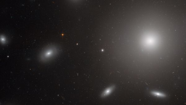 A photo of the center of the Coma Galaxy Cluster. The bright spherical shape is NGC 4874, a galaxy with an extremely powerful gravitational pull that is surrounded by globular clusters of stars. - Sputnik International