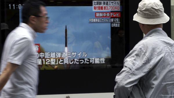 A man, right, watches a public TV screen broadcasting news of North Korea's launch of missile, in Tokyo - Sputnik International