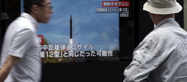 A man, right, watches a public TV screen broadcasting news of North Korea's launch of missile, in Tokyo - Sputnik International