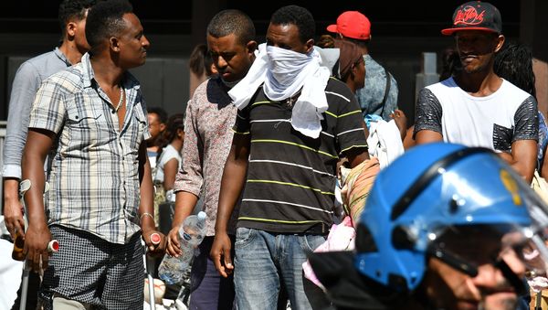 Refugees and asylum seekers wait after being displaced from a palace in the center of Rome on August 23, 2017 Refugees and asylum seekers wait after being displaced from a palace in the center of Rome on August 23, 2017 - Sputnik International