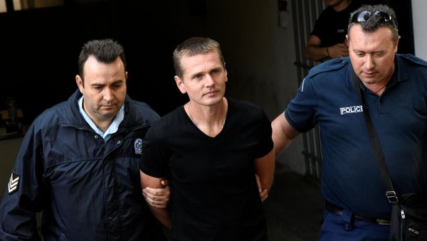 Alexander Vinnik, a 38 year old Russian man suspected of running a money laundering operation using bitcoin, is escorted by police officers while leaving a court in Thessaloniki, Greece, October 4, 2017 - Sputnik International